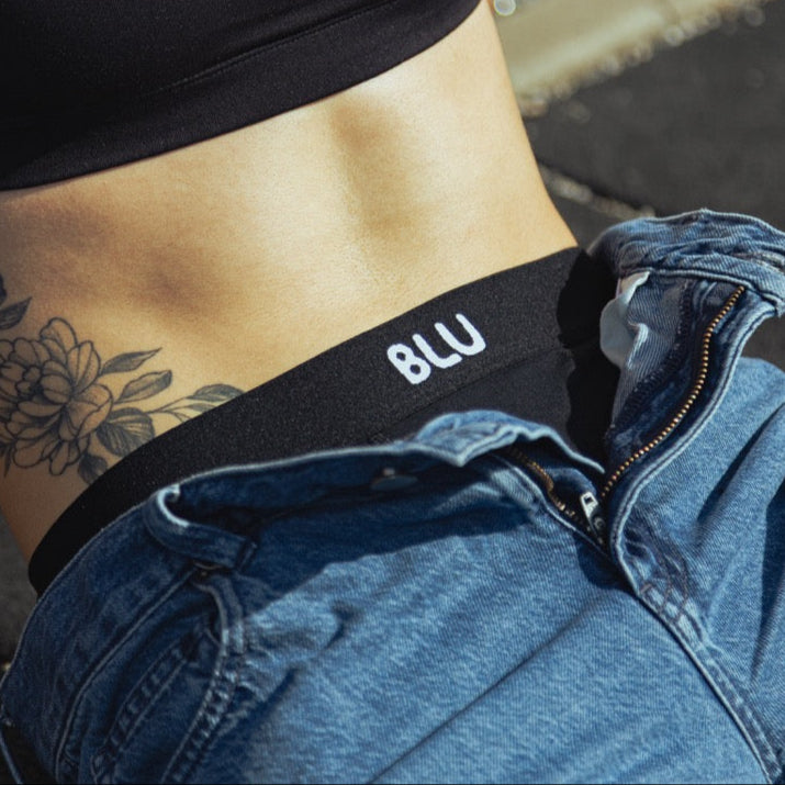Person trägt schwarze BLU Boxershorts aus Bio-Baumwolle, sichtbares Logo am Bund.