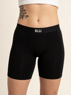 Black biker shorts with a white 'BLU' logo on the waistband, shown on a model against a light beige background.